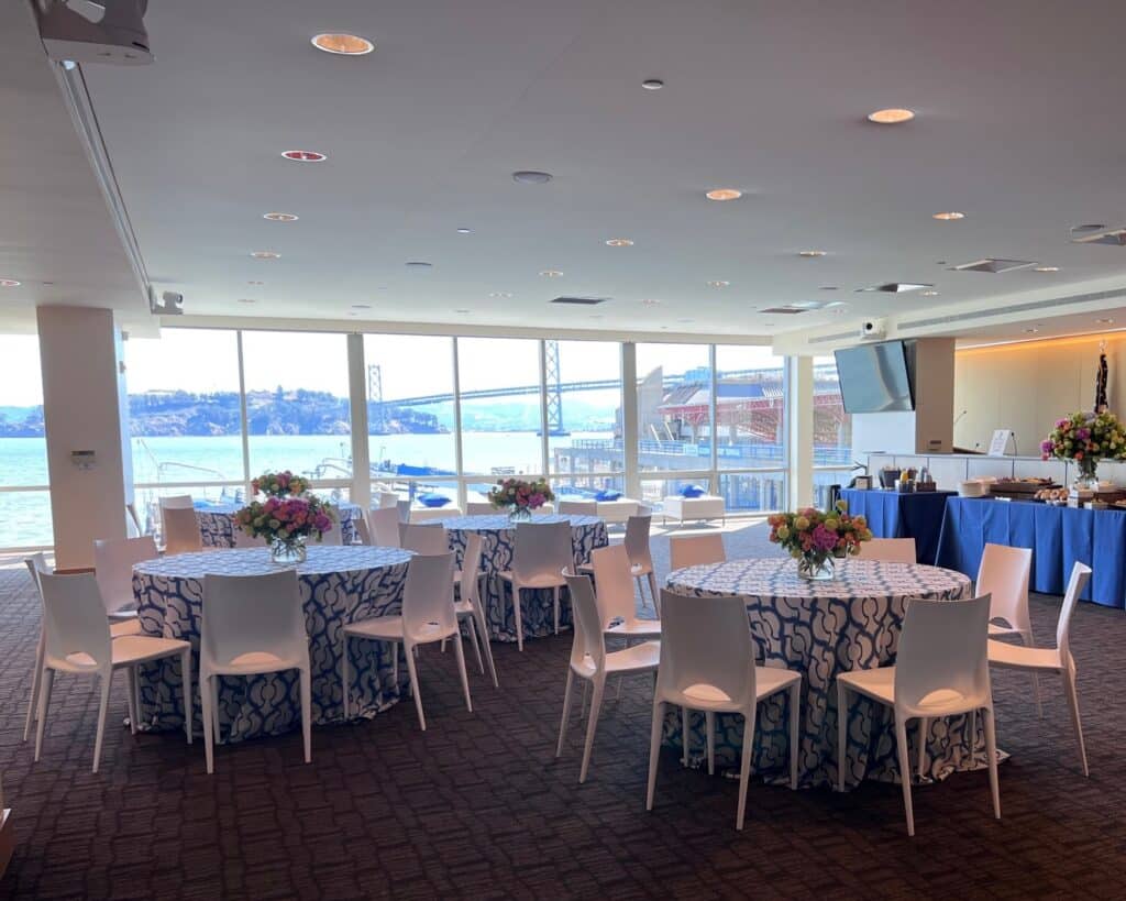 Event reception space with arranged tables and chairs.