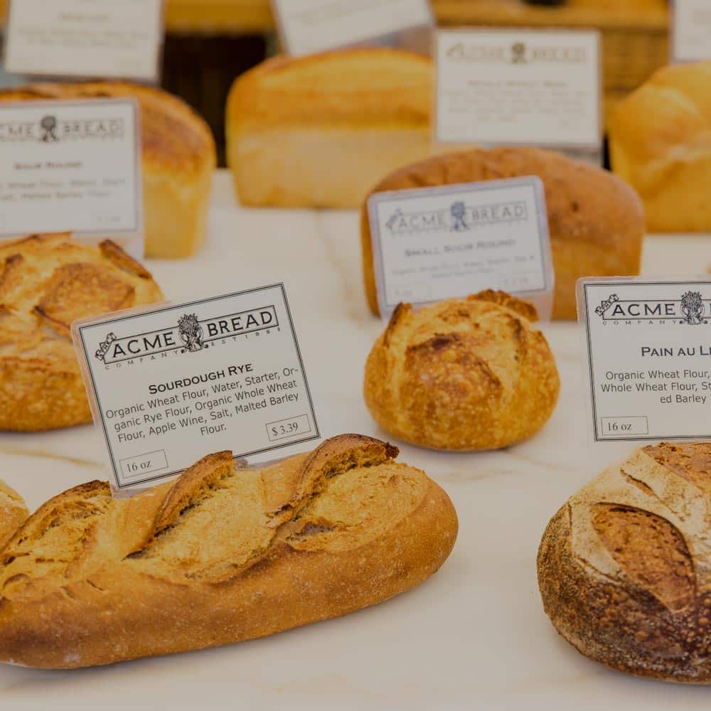 Assortment of fresh bread on a table with price tags.